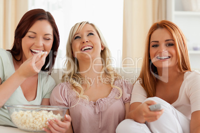 Charming women lounging on a sofa watching a movie