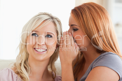 Young woman telling her friend a secret