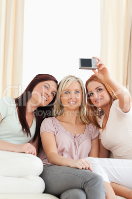 Young women lounging on a sofa with a camera