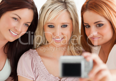 Charming women lounging on a sofa with a camera