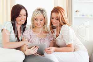 Cute women lounging on a sofa with a tablet