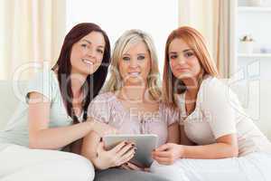 Gorgeous women lounging on a sofa with a tablet