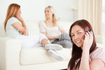 Gorgeous young Women chatting on a sofa one has a phone