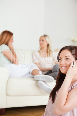 Cute young Women chatting on a sofa one has a phone