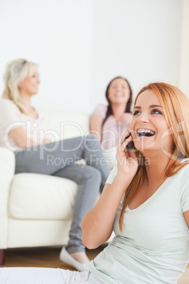 Laughing woman with a cellphone separated from the others