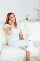 Young Woman sitting on a sofa with a cellphone