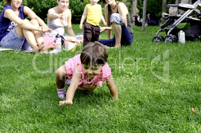 People Watching a Baby Crawling in the Park