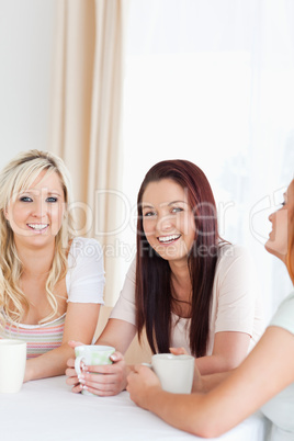 Gorgeous young Women sitting at a table with cups
