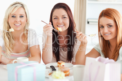 Charming Women sitting at a table eating a cake