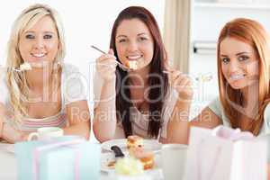 Charming Women sitting at a table eating a cake