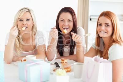 Gorgeous Women sitting at a table eating a cake