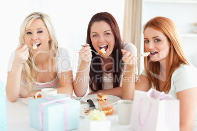 Good-looking Women sitting at a table eating a cake