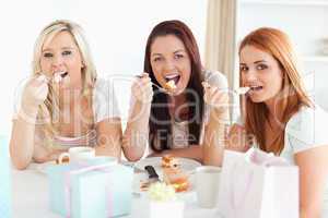 Good-looking Women sitting at a table eating a cake