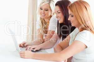 Smiling Women sitting at a table with a laptop