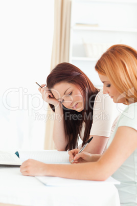 Concentrating Women sitting at a table doing their homework