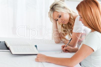 Exhausted Students sitting at a table doing their homework