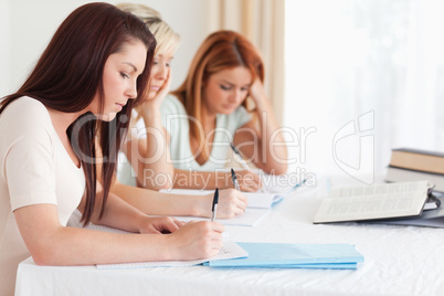 Portrait of bored Students learning at a table