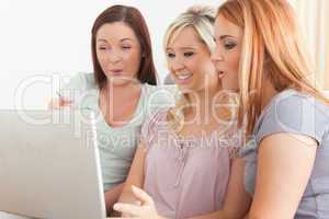 Charming women sitting on a sofa with a laptop