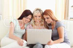 Cute women lounging on a sofa with a laptop