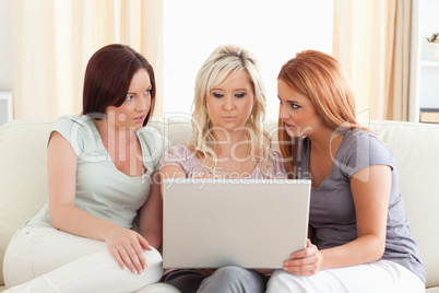 Charming women lounging on a sofa with a laptop