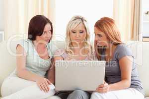 Charming women lounging on a sofa with a laptop