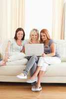 Cute women relaxing on a sofa with a laptop