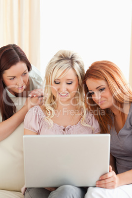 Charming women relaxing on a sofa with a laptop