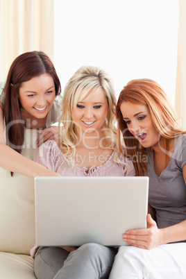Amazed women relaxing on a sofa with a laptop