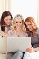 Amazed women relaxing on a sofa with a laptop