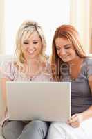 Friends relaxing on a sofa with a laptop