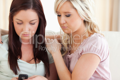 zwei Frauen sitzen mit Handy auf der Couch