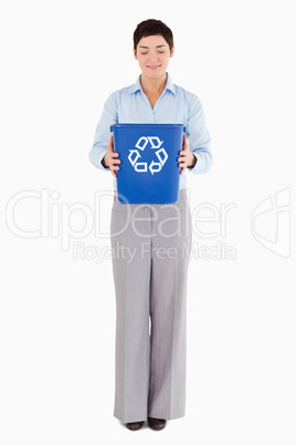 Businesswoman holding a recycling bin