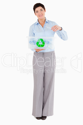 Woman putting a plastic bottle in a recycling box