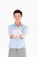 Businesswoman showing a piggy bank