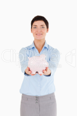 Smiling businesswoman holding a piggy bank