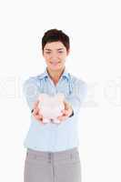 Serious woman holding a piggy bank