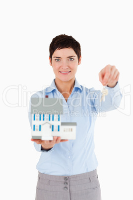 Real estate agent holding keys and a miniature house