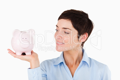 Close up of an office worker holding a piggy bank