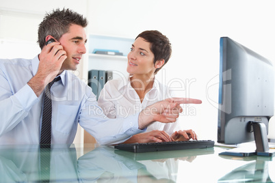 Close up of a man showing something to his coworker on a compute
