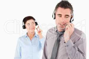 Office workers speaking through headsets