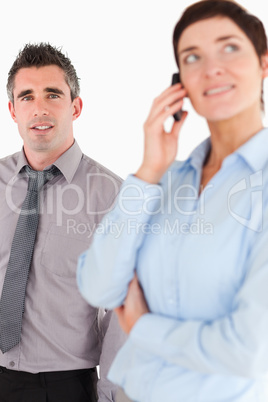 Portrait of a woman on the phone call while her coworker is posi