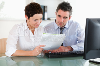 Female and male workers looking at a document