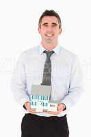 Businessman holding a miniature house