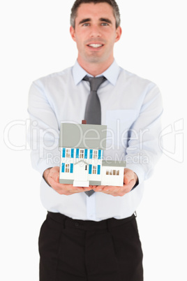 Real estate agent showing a miniature house