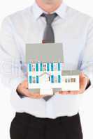 Portrait of a man holding a miniature house