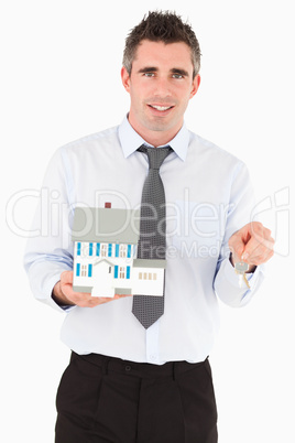 Businessman holding a key and a miniature house