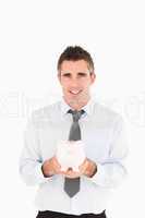 Portrait of a businessman showing a piggy bank