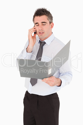 Portrait of a businessman making a phone call while holding a bi