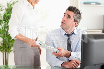 Business manager receiving a document from his secretary