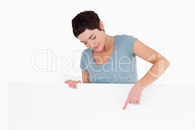 Woman pointing at copy space on a panel